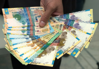 A Kazakh National Bank employee shows a set of Kazakhstan's new tenge notes during an official presentation in Almaty in this August 28, 2006 file photo. The Kazakhstan central bank has misspelled the word "bank" on its new notes, officials said on October 18, 2006. The Kazakh word for bank is the Cyrillic form of "bank". On the new note, the word was written with an alternate Kazakh form of the letter K, which has a slightly different pronunciation.    Picture taken August 28, 2006.  REUTERS/Dmitry Podlipayev  (KAZAKHSTAN) - RTR1IH8E