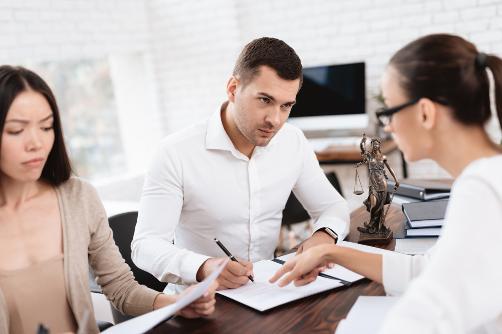 The couple went to a lawyer to conclude an agreement on the divorce. They quarrel and argue with each other. Lawyer prepares documents.