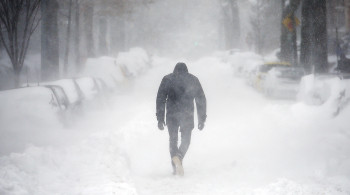 A man walks along a street covered by snow during a winter storm in Washington January 23, 2016. A winter storm dumped nearly 2 feet (58 cm) of snow on the suburbs of Washington, D.C., on Saturday before moving on to Philadelphia and New York, paralyzing road, rail and airline travel along the U.S. East Coast. REUTERS/Carlos Barria      TPX IMAGES OF THE DAY      - GF20000104585