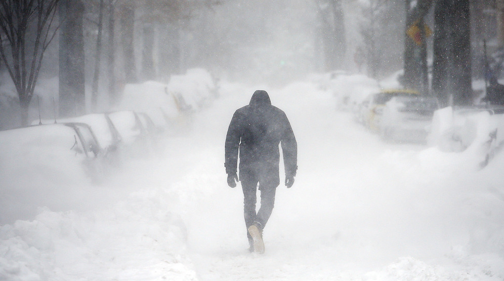 A man walks along a street covered by snow during a winter storm in Washington January 23, 2016. A winter storm dumped nearly 2 feet (58 cm) of snow on the suburbs of Washington, D.C., on Saturday before moving on to Philadelphia and New York, paralyzing road, rail and airline travel along the U.S. East Coast. REUTERS/Carlos Barria TPX IMAGES OF THE DAY - GF20000104585