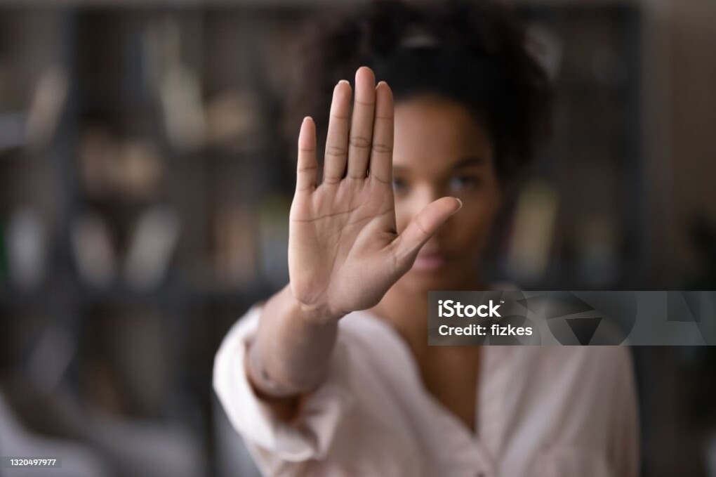 Close up focus on female mixed race palm hand showing stop sign, serious african american woman protesting against bullying in society, sexual or racial discrimination, denying family abuse indoors.