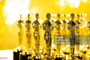 Group of golden statuette on shiny yellow background.