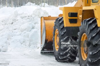 The bulldozer cleans the road after a blizzard