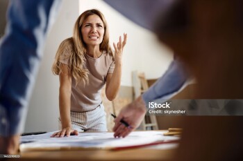 Displeased woman arguing with a building contractor while having problems with plans in the apartment.