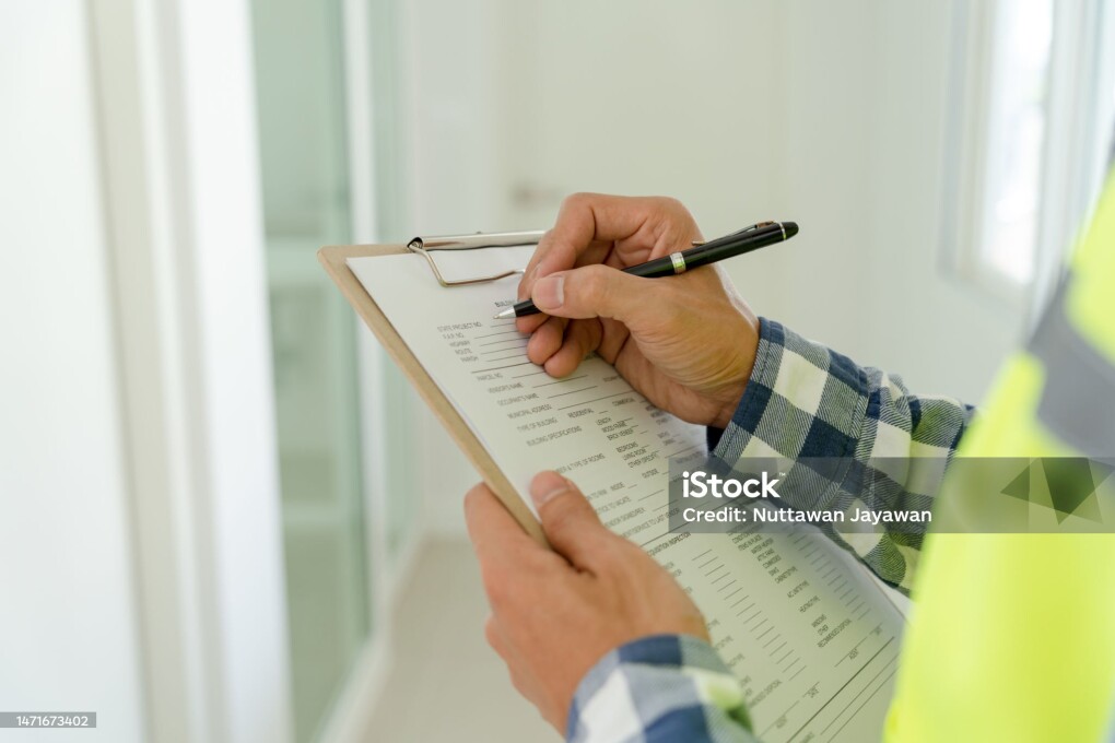 inspector or engineer is inspecting construction and quality assurance new house using a checklist. Engineers or architects or contactor work to build the house before handing it over to the homeowner