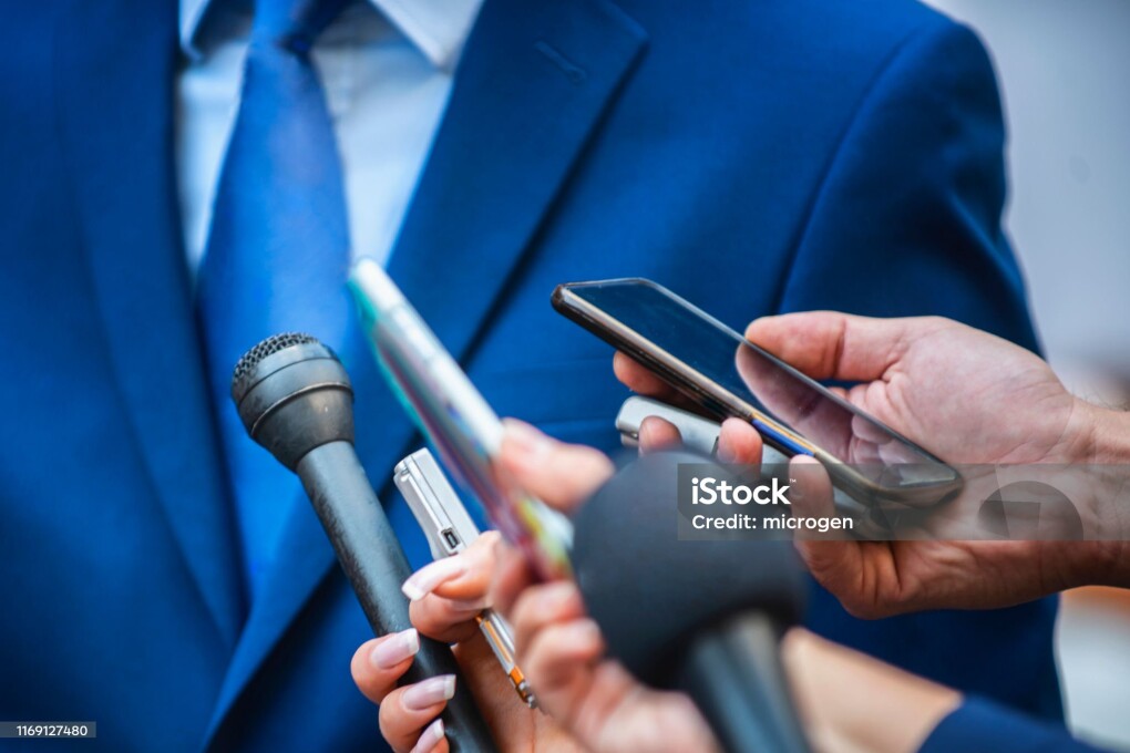 Media Interview - journalists with microphones interviewing formal dressed politician or businessman.