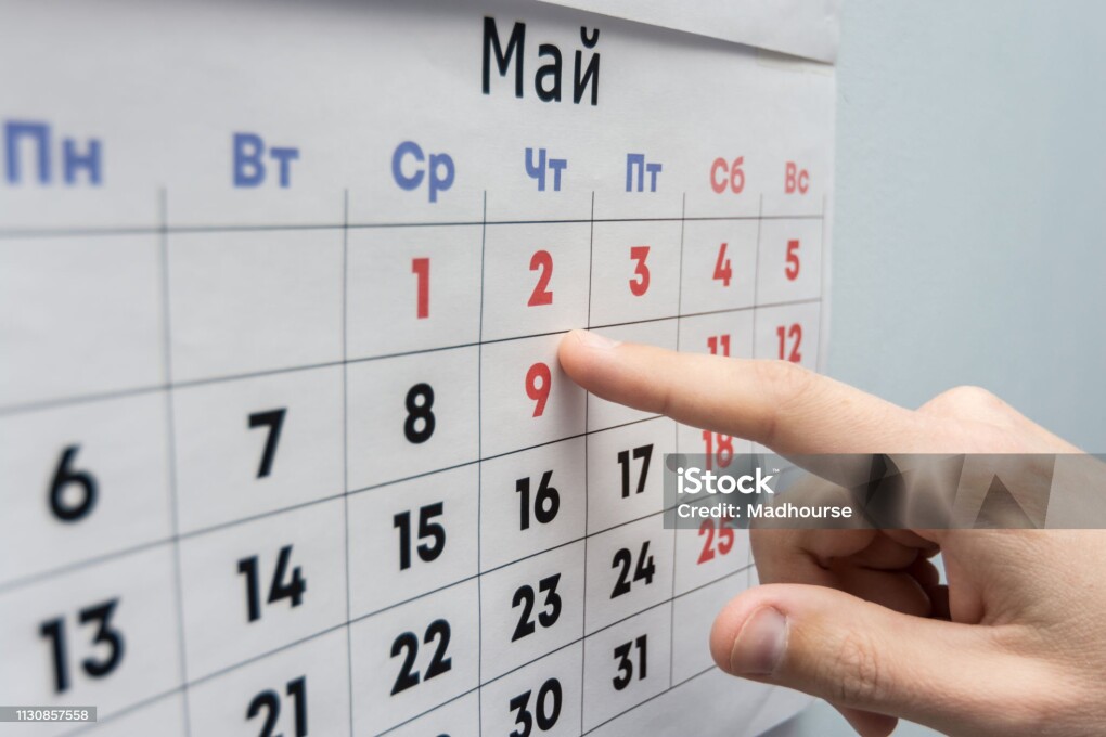 Hand points to the May 2 holiday on a wall calendar sheet