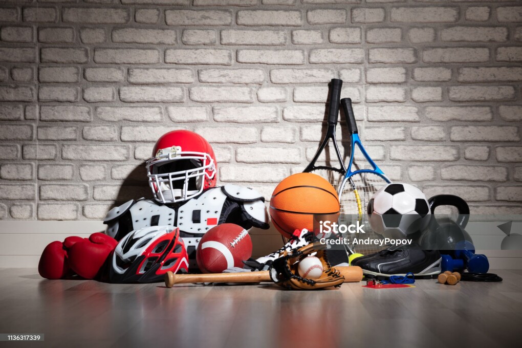 Various Sport Equipment On Floor In Front Of Brick Wall