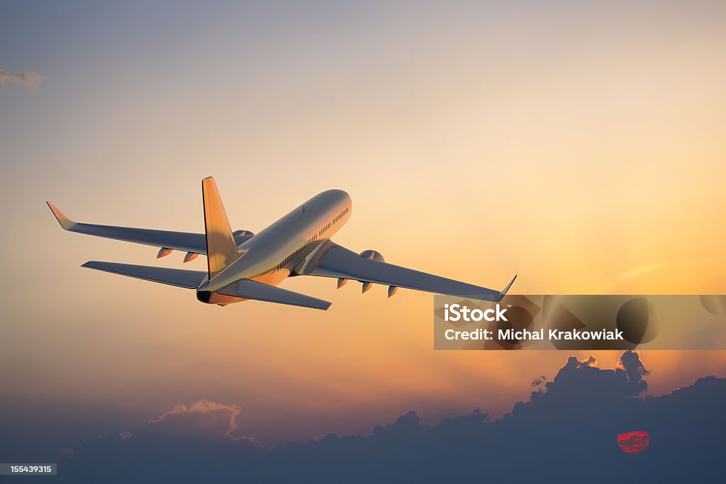 Passanger airplane flying above clouds in evening.