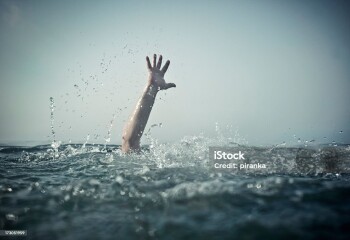 Hand reaching out of deep water, focus on water splash