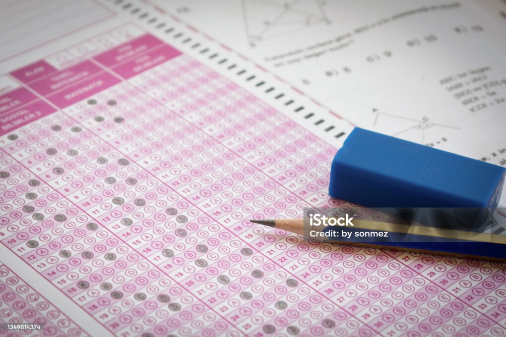 pencil and eraser on test answer sheet, with question booklet