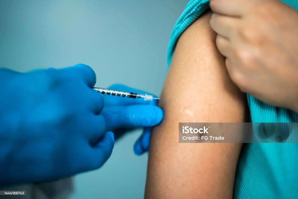 Doctor's hands vaccinating a woman