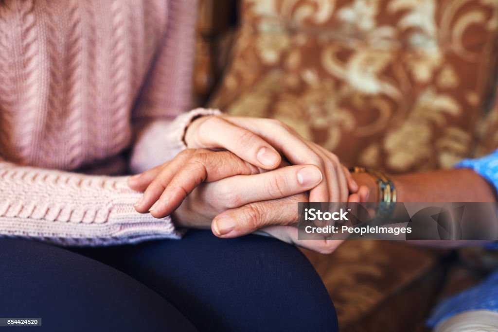 Cropped shot of unrecognizable women holding hands at home