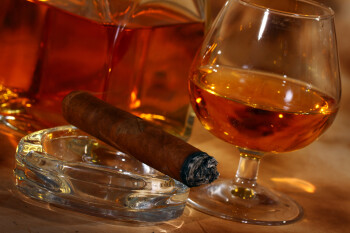 Cold whiskey  and cigar against ancient background