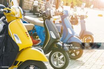 Multicolored mopeds in the parking lot in the city