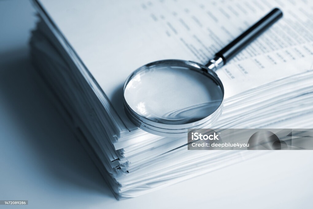 Magnifying glass on a stack of documents