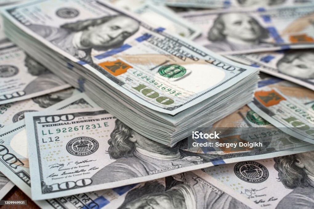 Stack of one hundred dollars notes on dollars background