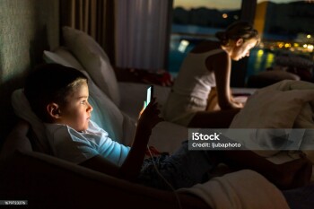 Mother with boy using laptop and smartphone.