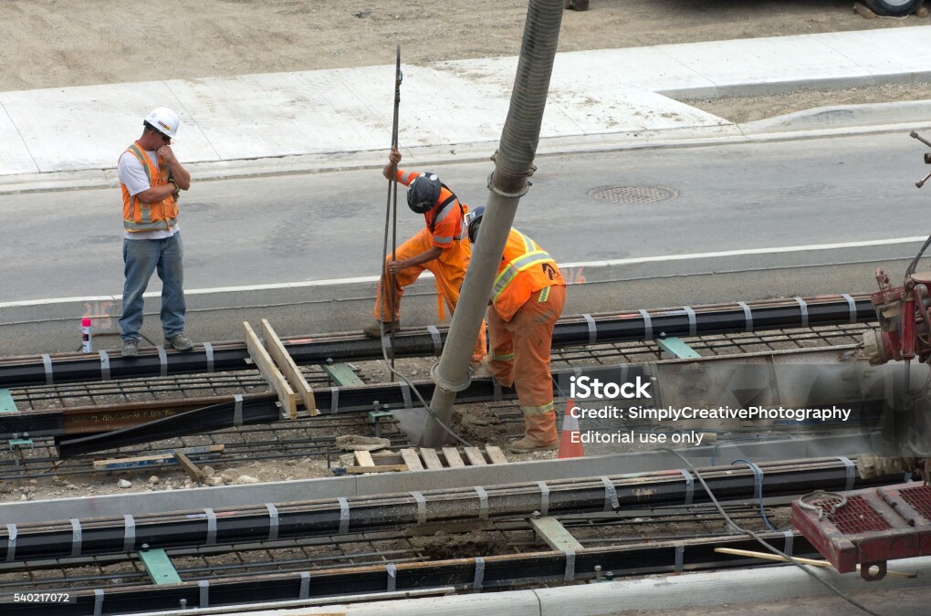 Kitchener, Ontario, Canada - June 13, 2016: Workers prepare rail track for pouring of cement during light rail transit line construction in Kitchener, Ontario.