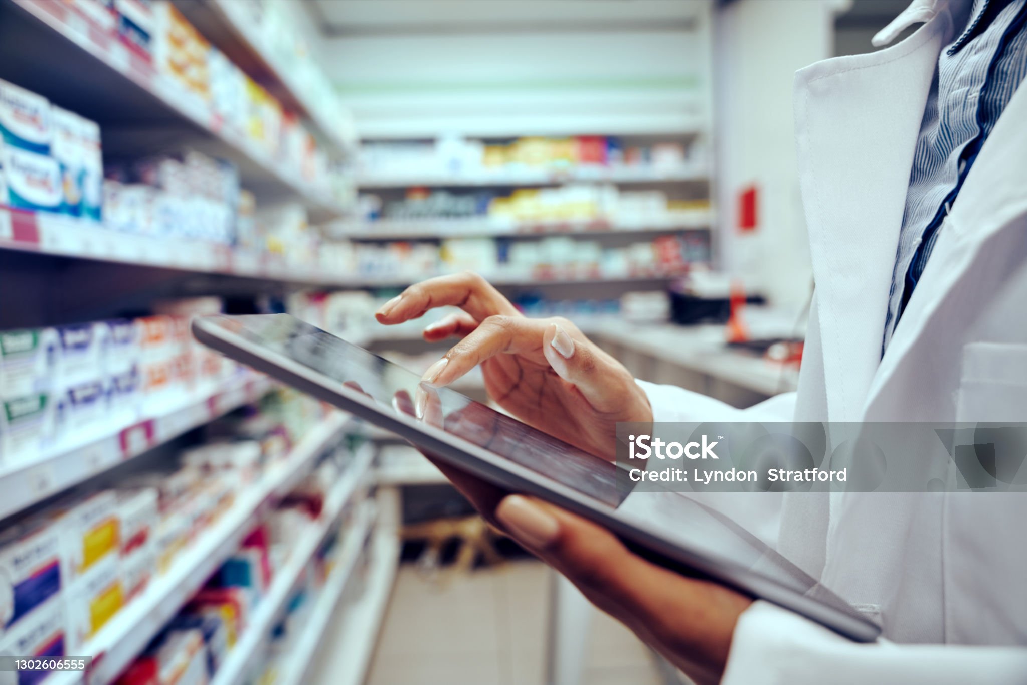 Closeup of hands of young female pharmacist checking inventory using digital tablet