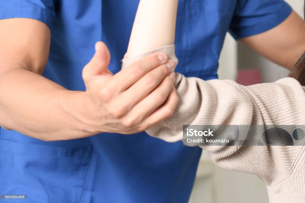 Male physiotherapist massaging and female patient receiving massage