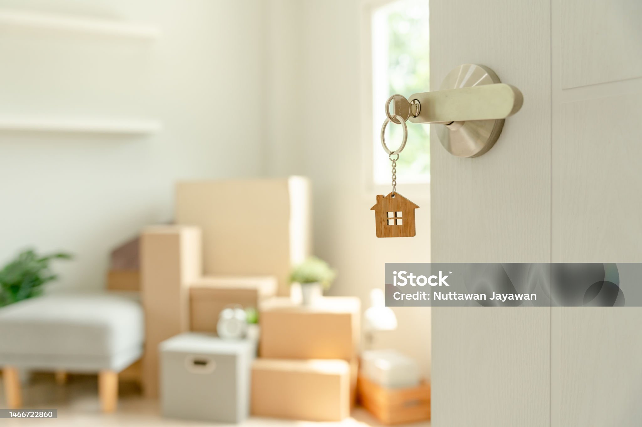Moving house, relocation. The key was inserted into the door of the new house, inside the room was a cardboard box containing personal belongings and furniture. move in the apartment or condominium