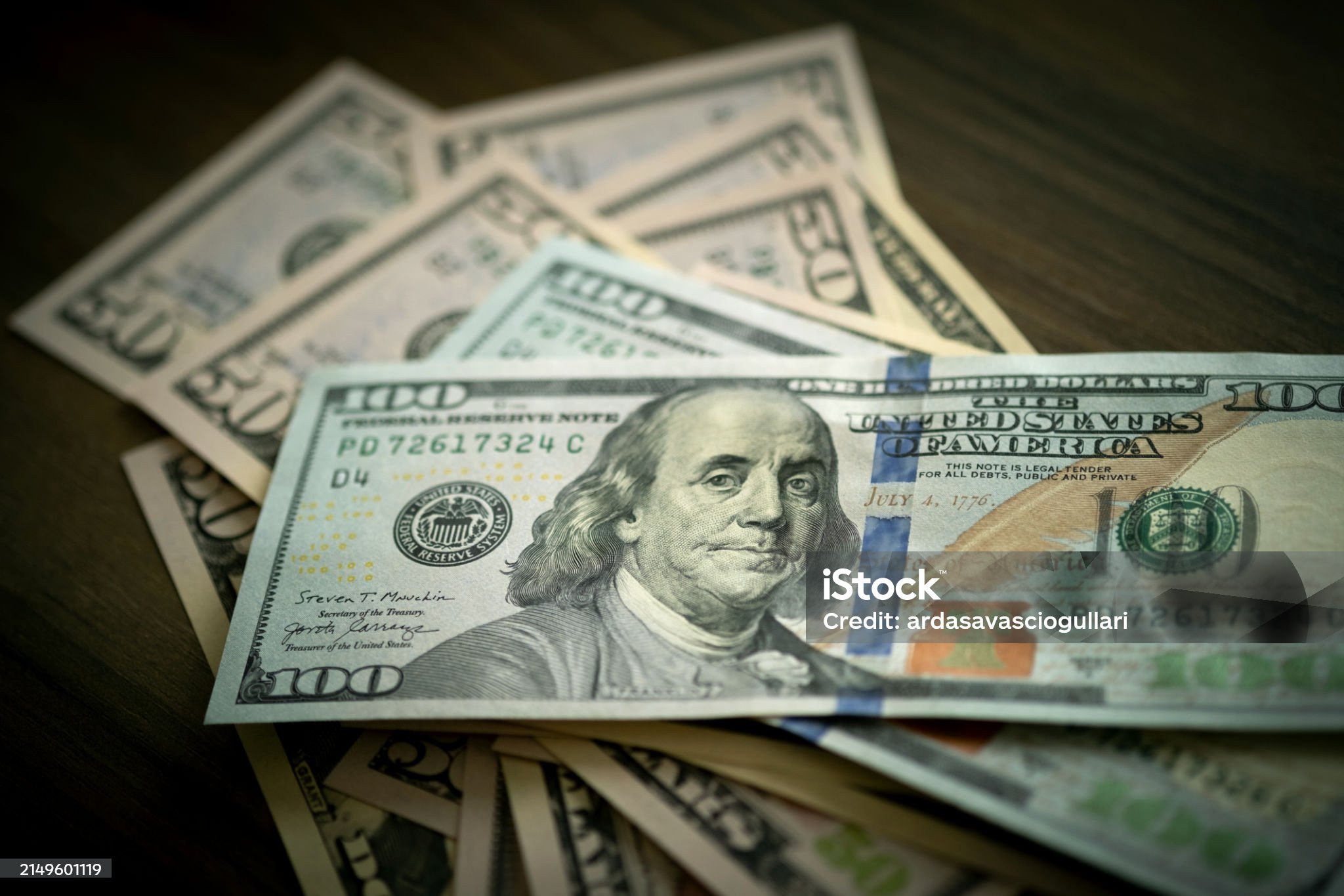 A thoughtful arrangement of $50 and $100 bills graces the desktop, highlighting wealth's textures.