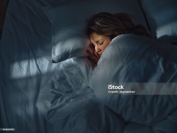 High angle view of a woman taking a nap in her bed at night. Photographed in medium format.