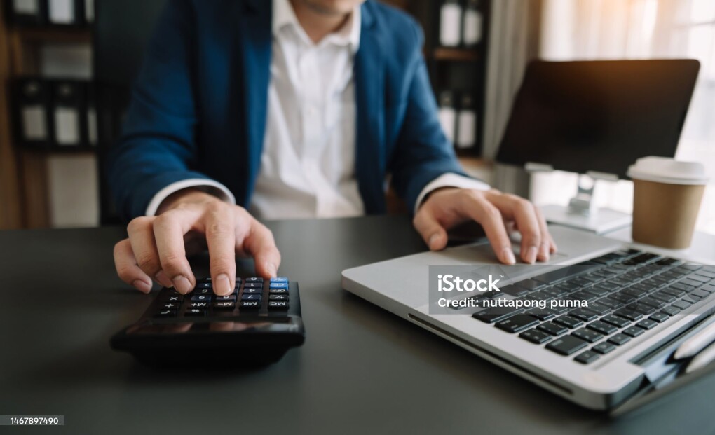 Close up of businesswoman or accountant hand typing laptop working to calculate on desk about cost at home office.