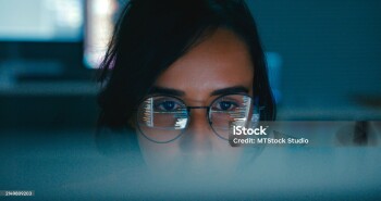 Closeup of Female computer programmer works on complex software development tasks at her home office late into the night. Software developer, artificial intelligence and programming concept.
