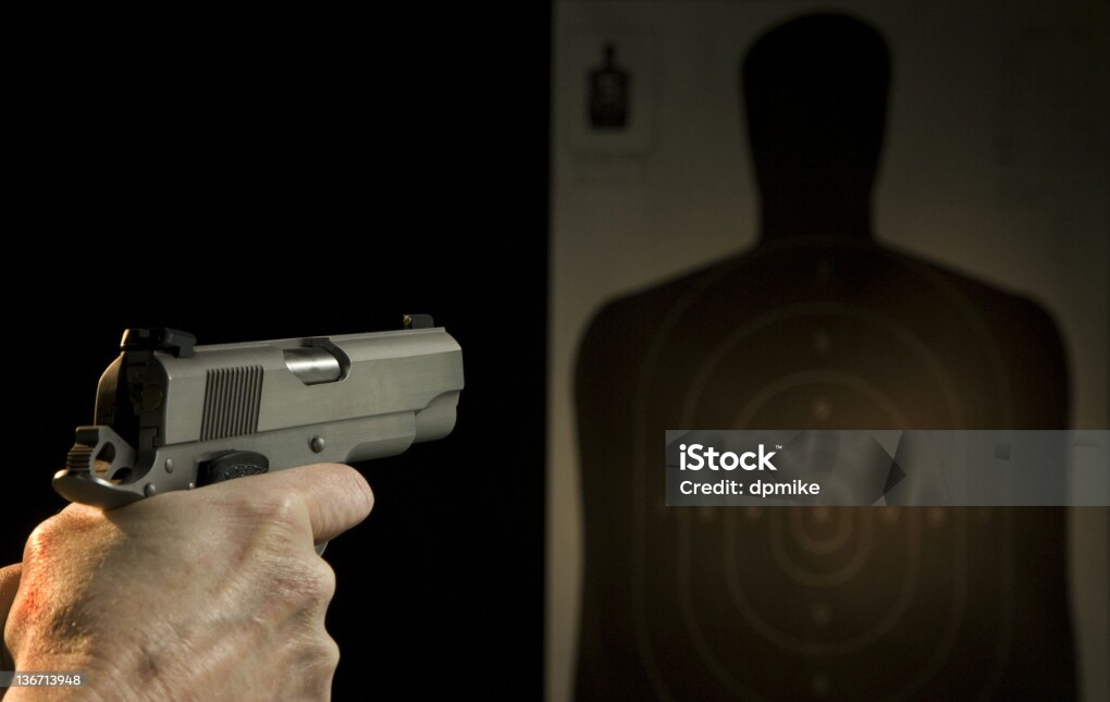 .45 caliber hand gun with silhouette target in the background