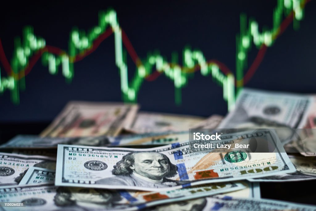 US dollar bills on background with dynamics of exchange rates. Trading and financial risk concept