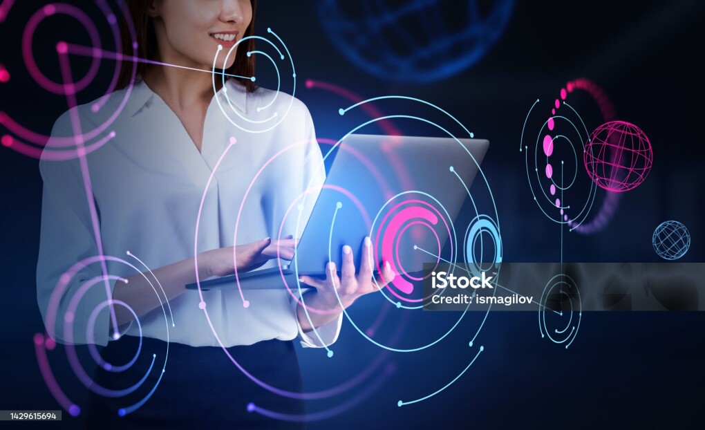 Businesswoman smiling and typing in laptop, abstract metaverse hologram double exposure. Colorful circuit of connection in virtual world. Concept of global connection