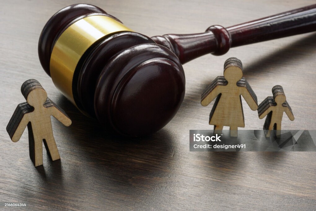 Divorce and alimony concept. Divided family figurines and gavel.