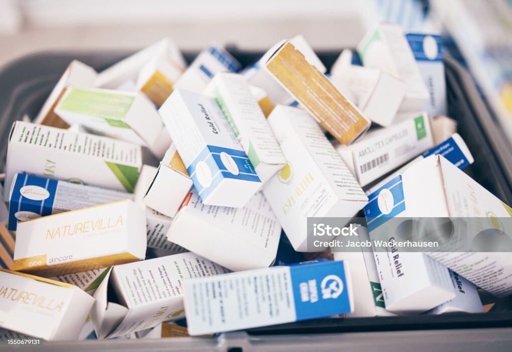 Closeup of medicine, boxes and shopping in pharmacy, drugstore service and consumer market. Retail dispensary, pharmaceutical stock and basket of pills, supplements and products of medical tablets