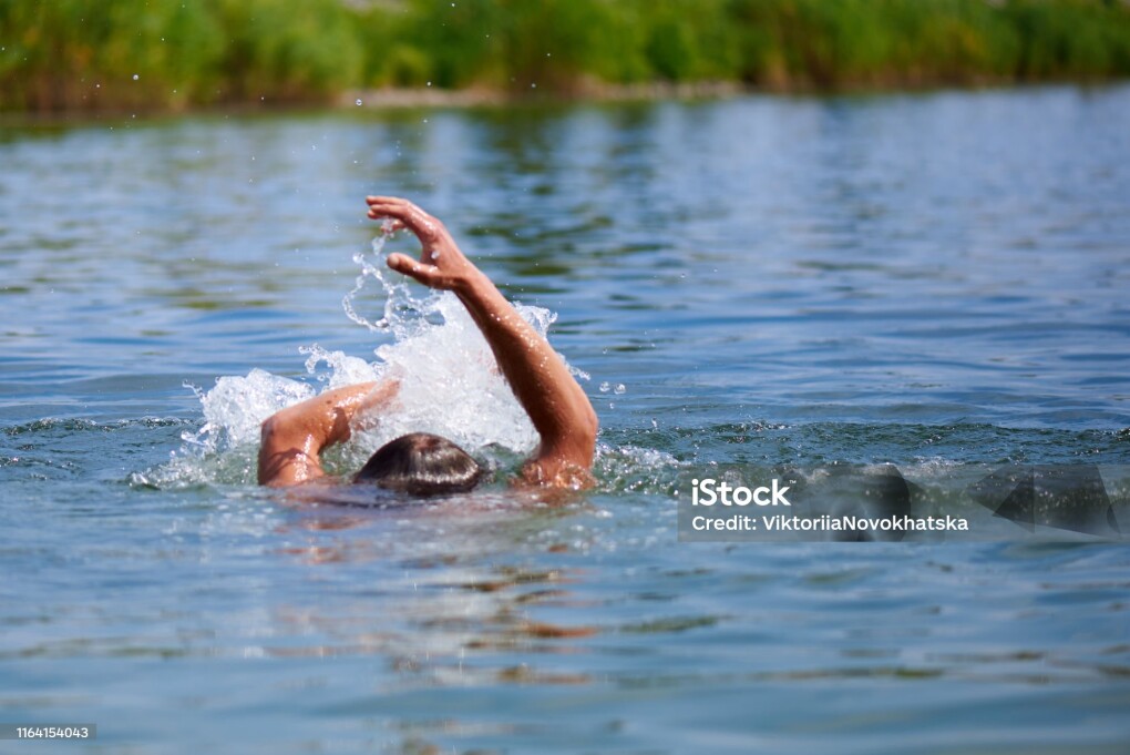 Splashes of water from a drowning man in a pond. Copy space.