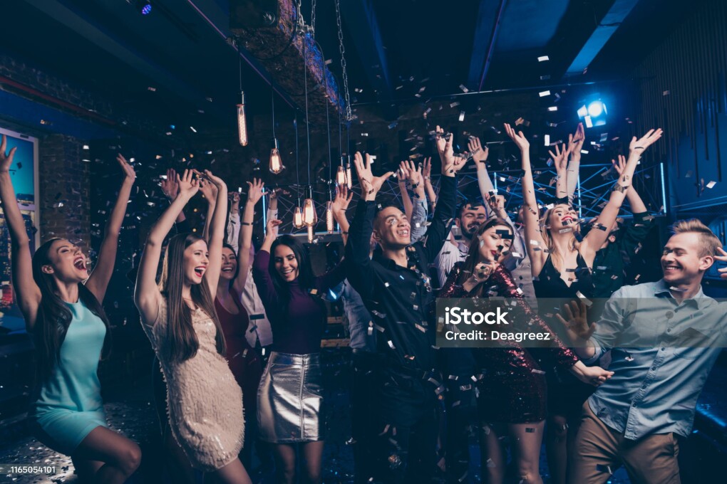 Portrait of cute good-looking funny funky millennial formal wear lights, dance floor spotlight raise hands fellows buddies indoors enjoy meeting