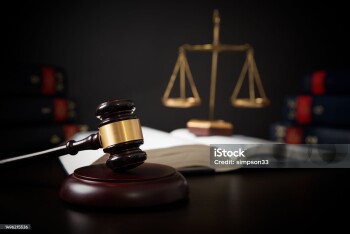 Gavel leaning against a row of law books, law theme