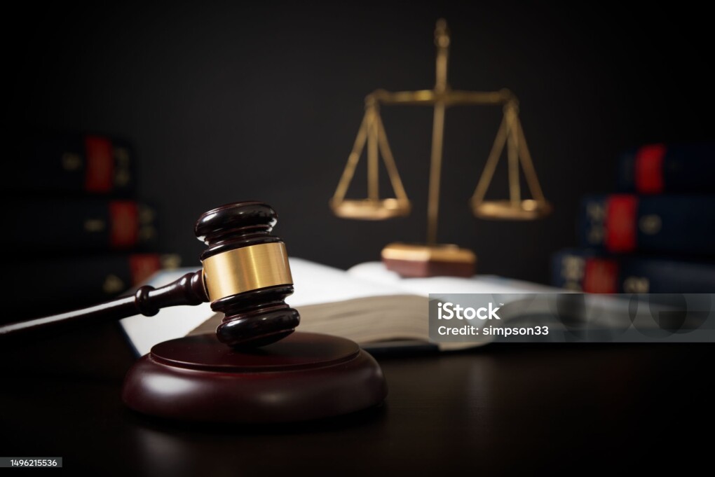 Gavel leaning against a row of law books, law theme
