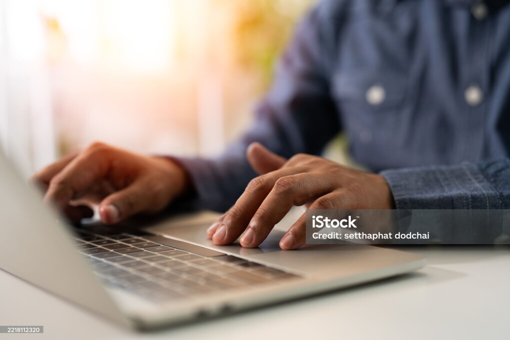 A man using and typing keyboard of laptop computer communicates on internet technology with paperwork on office desk. Workplace, Businessman professional busy working on new job project idea.