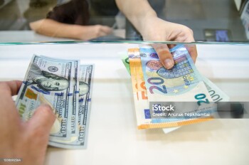 Exchange money, Exchange US dollar or American dollars (USD) for EUR money, A man and women are exchanging dollars for euros.