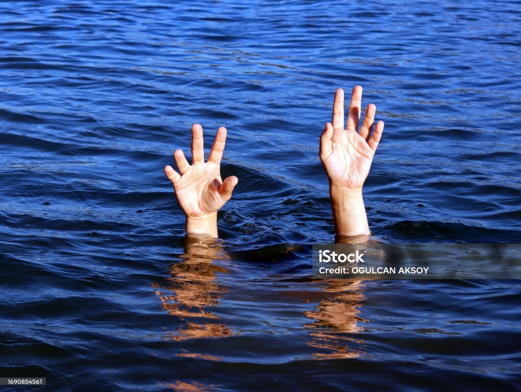 Pair of Female Hands In Blue Sea Water stock photo.