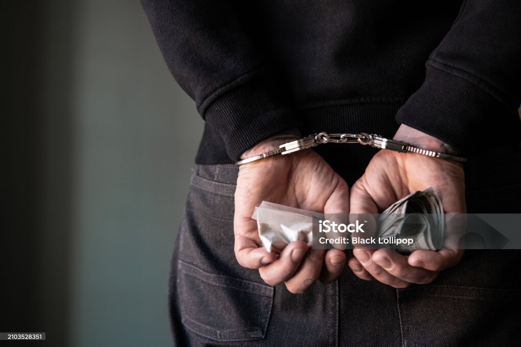 A criminal with handcuffs behind his back.