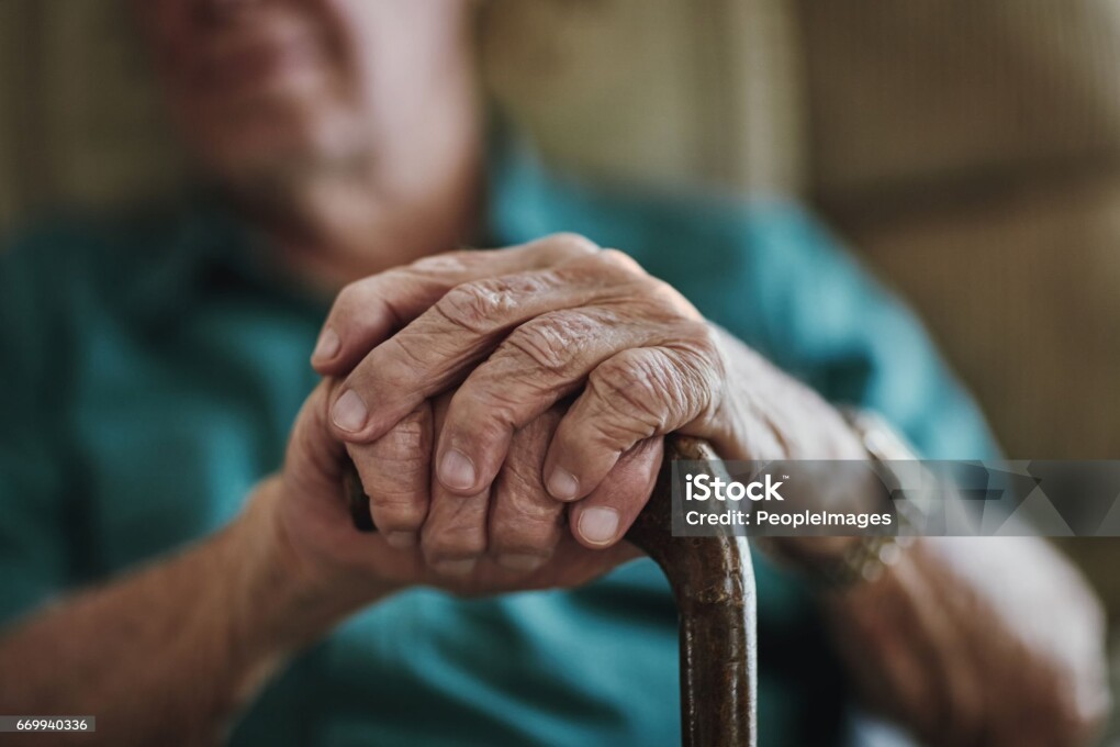 Cropped shot of an unrecognizable man leaning on his walking stick