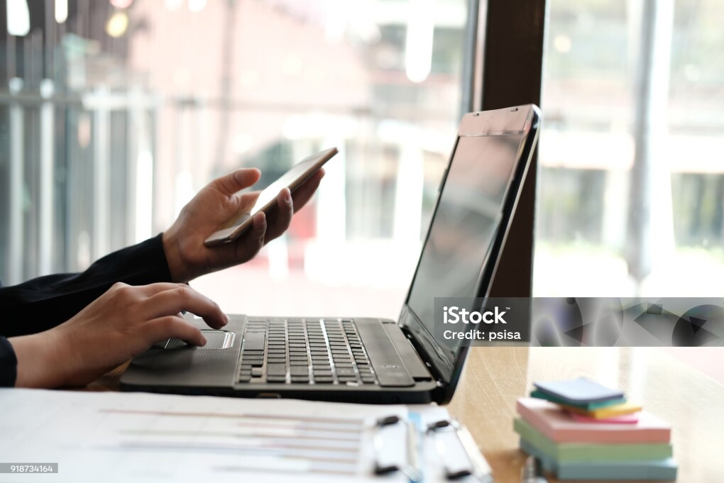 businesswoman holding mobile phone at office. young female entrepreneur using smartphone at cafe. freelance woman working with computer at coffee shop. business concept