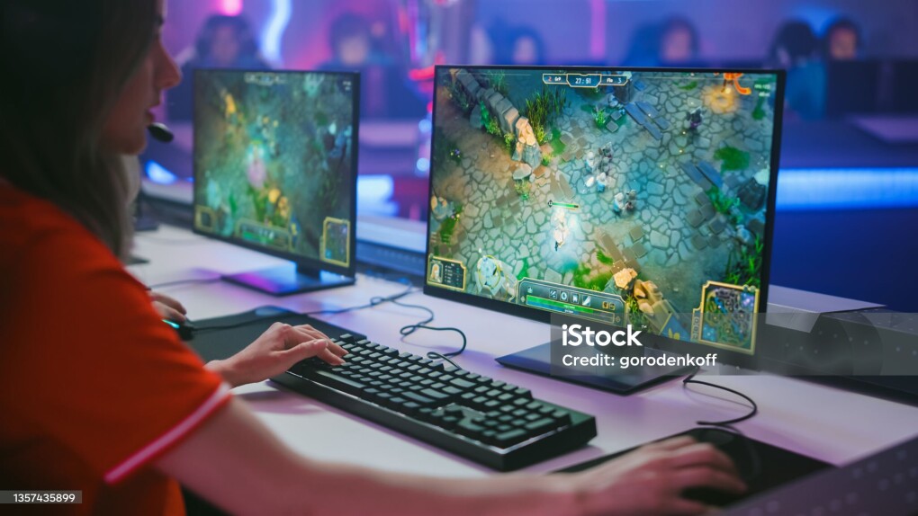 Pro Girl Plays Computer Game Plays RPG Strategy on a Championship. Diverse Esport Team of Pro Gamers Play in Mock-up Video Game. Stylish Neon Cyber Games Arena. Over The Shoulder Shot