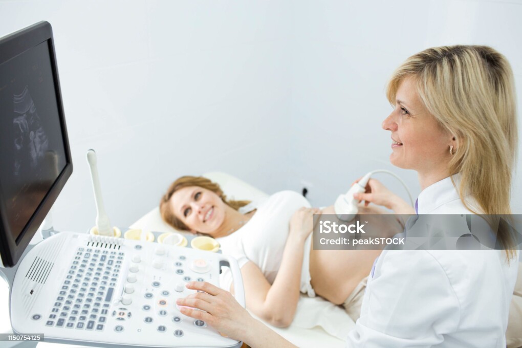 Happy woman looking at ultrasound results with her doctor in examination room