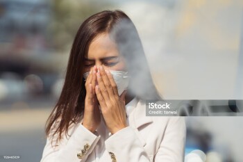 Asian woman are going to work.she wears N95 mask.prevent PM2.5 dust and smog.she is coughing