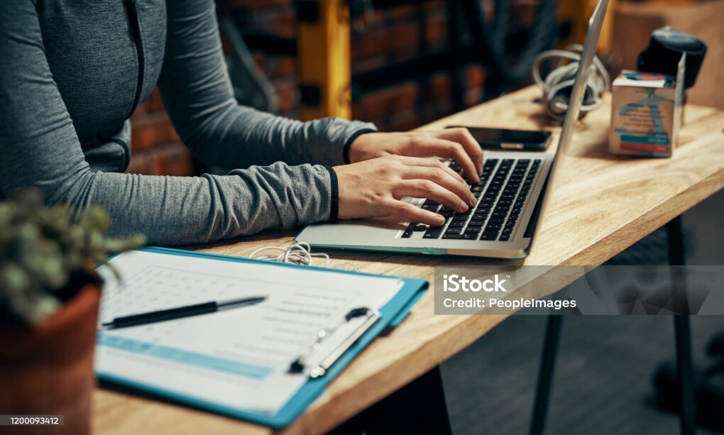 Cropped shot of an unrecognizable woman using a laptop at her desk