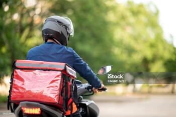 The staff prepares the delivery box on the motorcycle for delivery to customers.